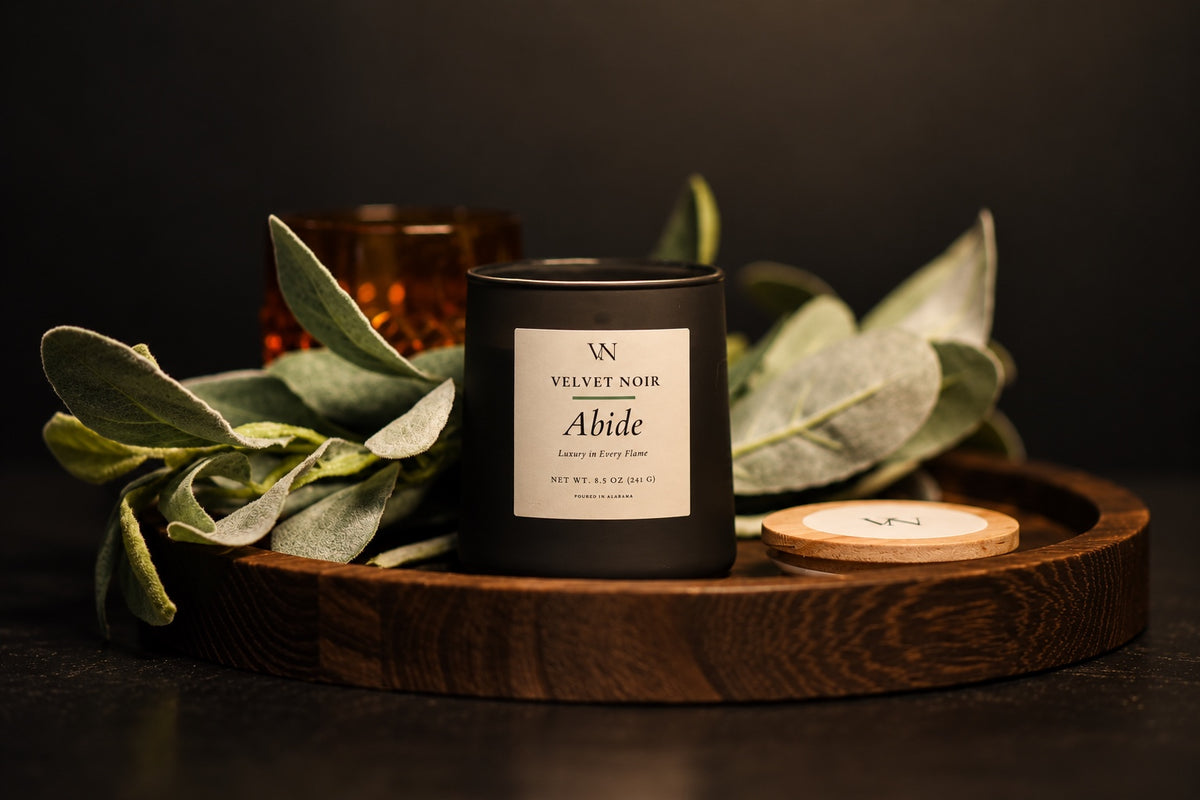 Velvet Noir Abide candle styled with sage leaves