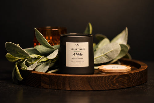 Velvet Noir Abide candle styled with sage leaves